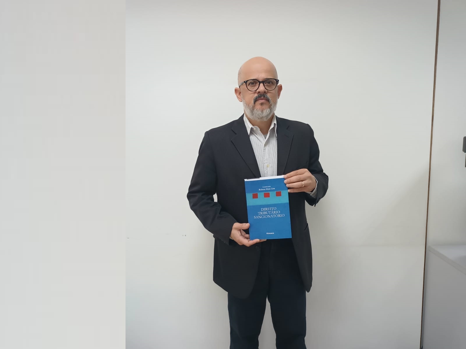 Luiz Claudio Nogueira segura o livro