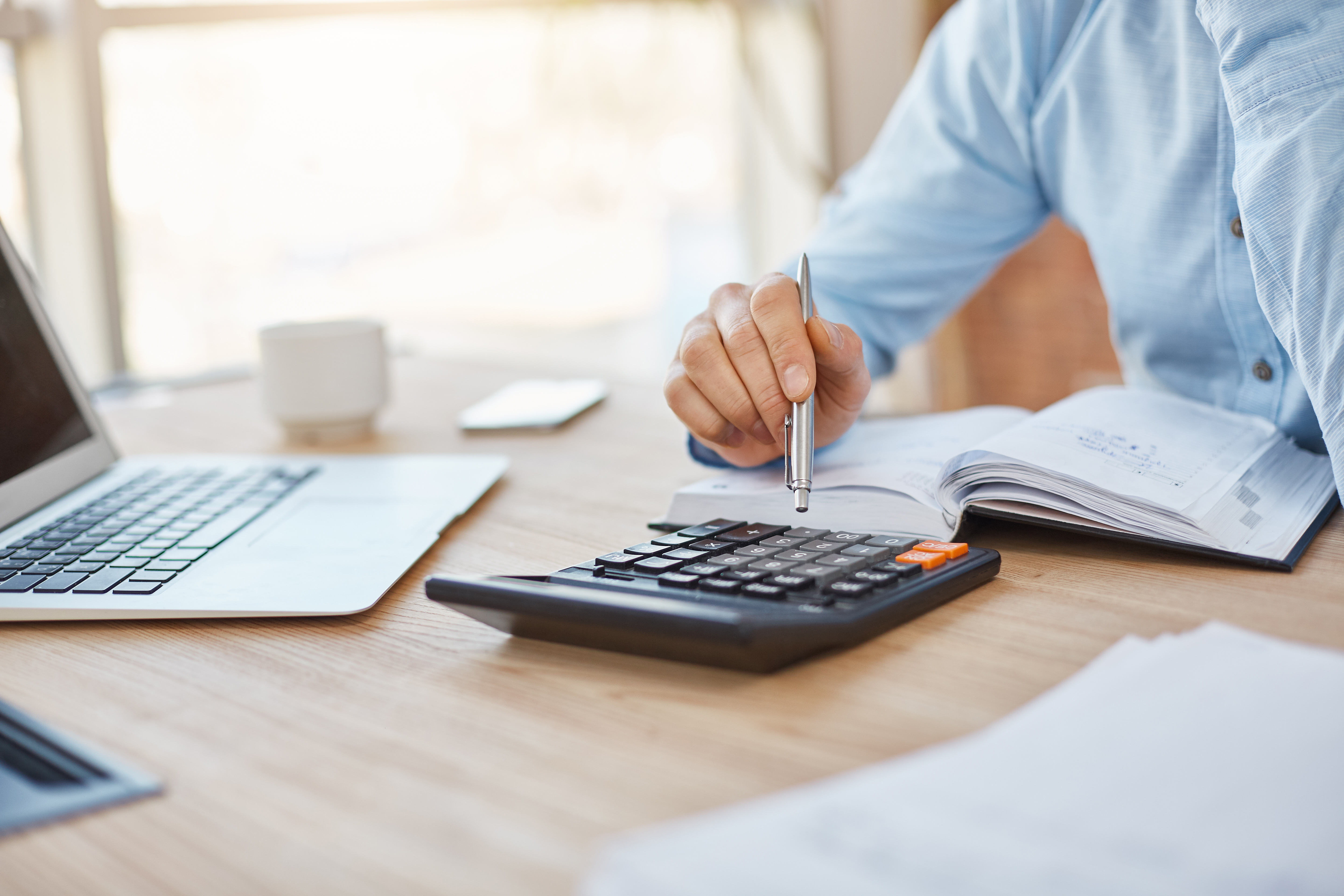 close-up-detail-professional-serious-accountant-sitting-light-office-checking-company-finance-profits-calculator|||Fotógrafo:Freepik