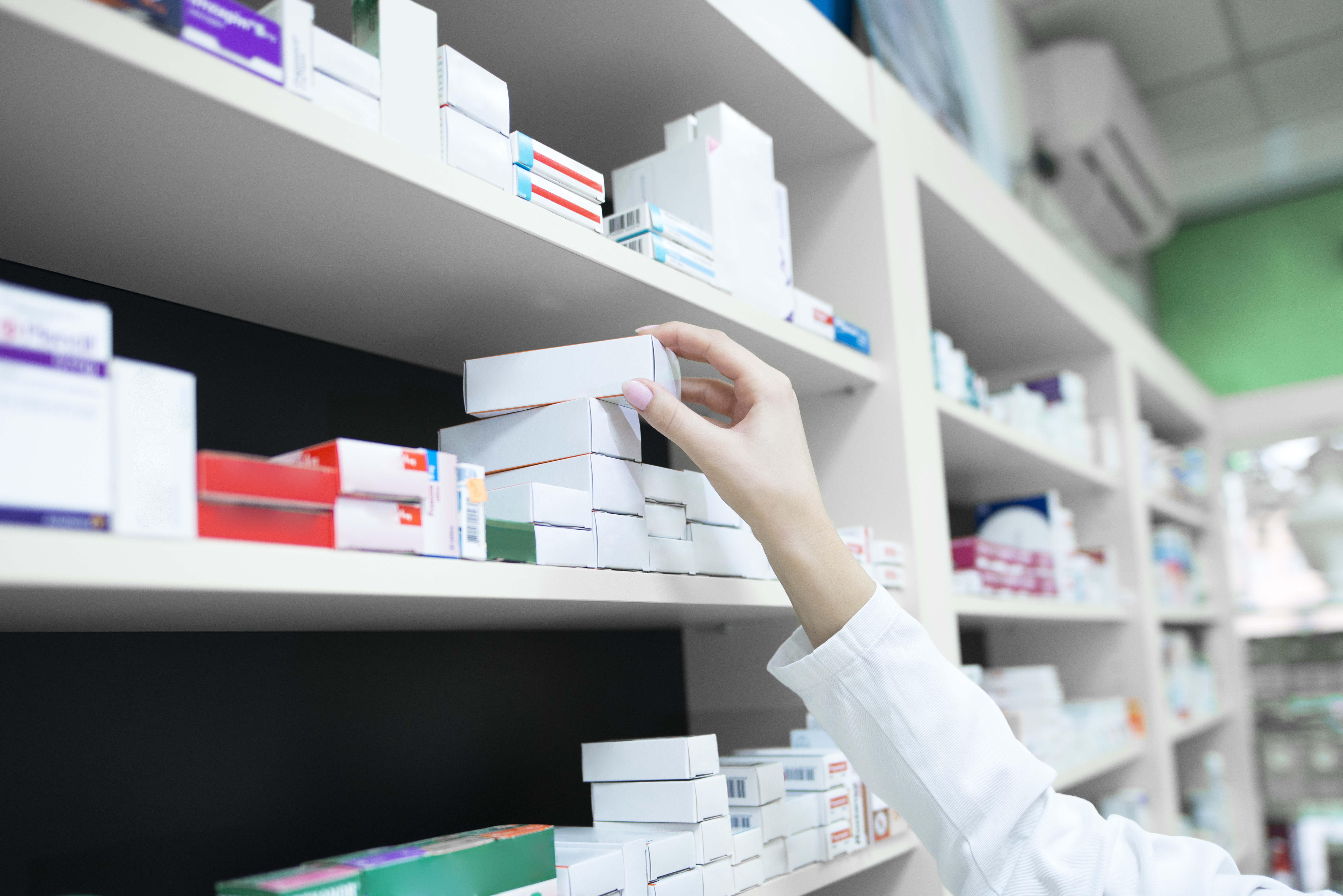 closeup-vista-da-mao-do-farmaceutico-tirando-a-caixa-de-remedios-da-prateleira-da-farmacia|||Fotógrafo:Freepik